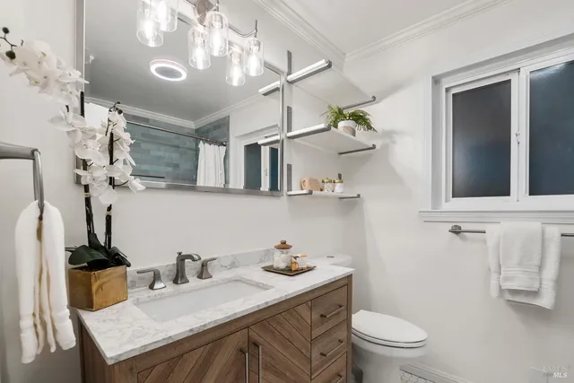 a bathroom with a granite countertop toilet sink and mirror