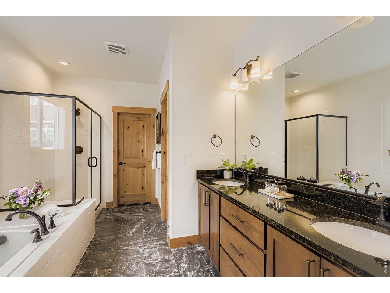2012 Day Spring Drive Windsor, CO 80550 - Photo 15 of 31 Elegant primary bath featuring a soaking tub, dual sink vanity, and stylish custom tile.