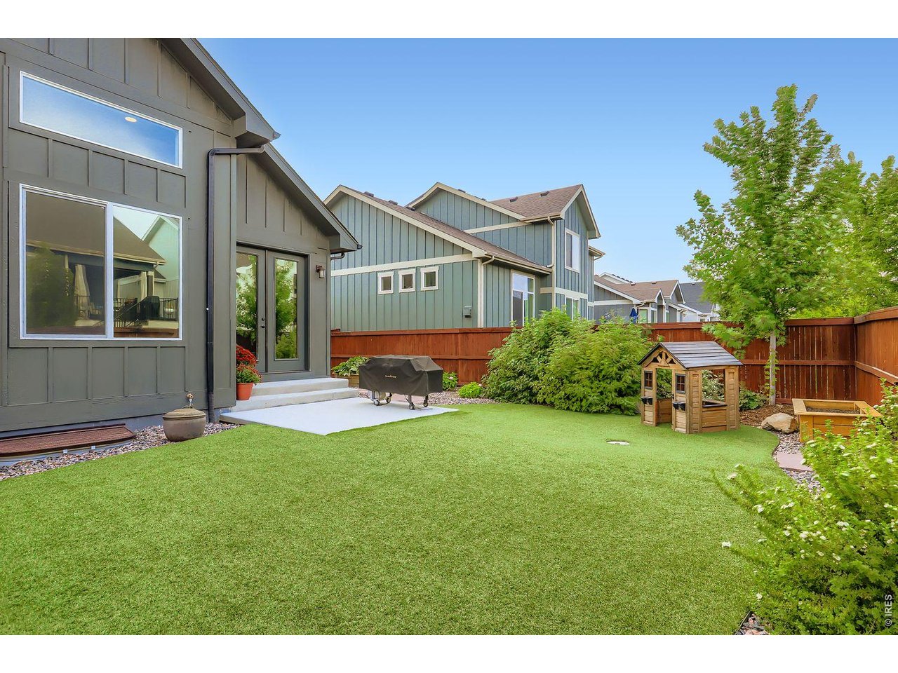 2012 Day Spring Drive Windsor, CO 80550 - Photo 27 of 31 Professionally landscaped backyard with artificial turf, perfect for playtime, entertaining, and low-maintenance outdoor living.