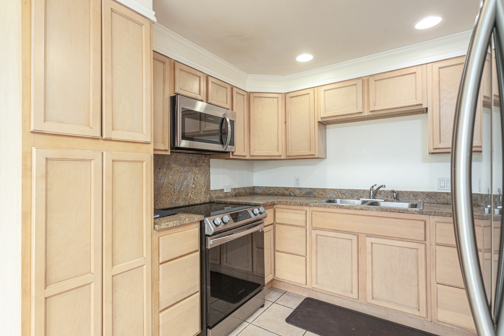 4580 Mamane Street Kapaa, HI 96746 - Photo 4 of 30 a kitchen with granite countertop white cabinets stainless steel appliances and a sink