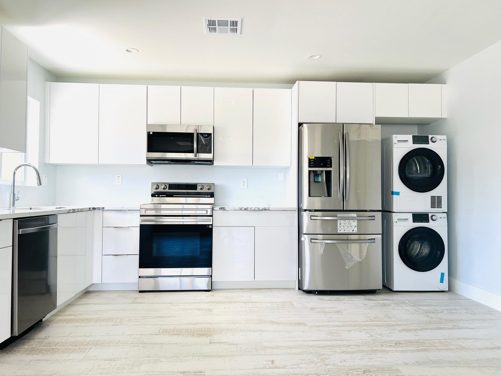 206 Southeast 1st Avenue, Unit 5 Delray Beach, FL 33444 - Photo 2 of 8 a kitchen with a refrigerator and a stove top oven