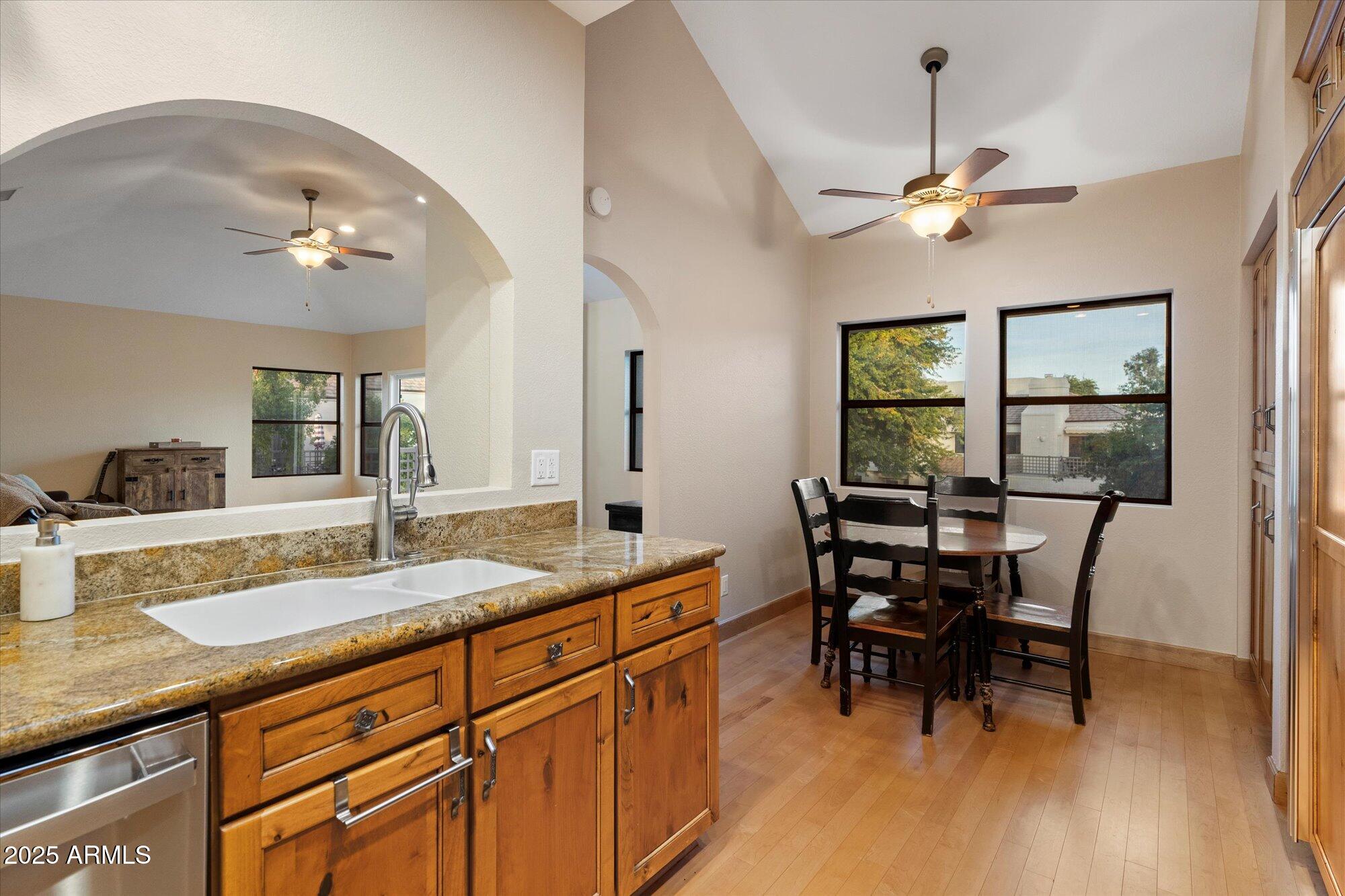 7272 East Gainey Ranch Road, Unit 104 Scottsdale, AZ 85258 - Photo 15 of 45 a dining hall with stainless steel appliances granite countertop furniture and a wooden floor