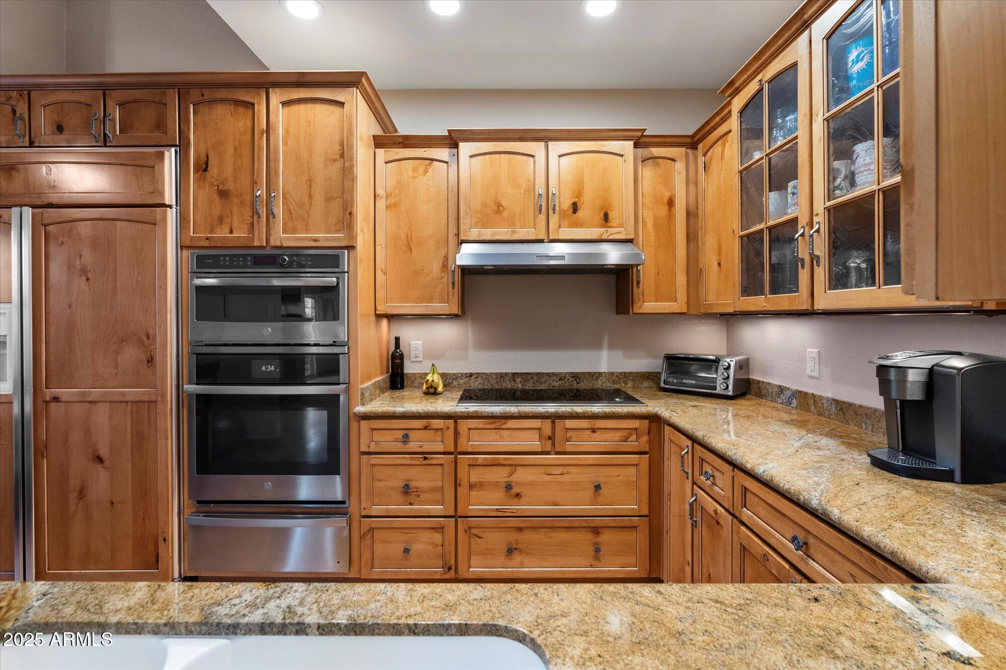 7272 East Gainey Ranch Road, Unit 104 Scottsdale, AZ 85258 - Photo 16 of 45 a kitchen with stainless steel appliances granite countertop a refrigerator and cabinets