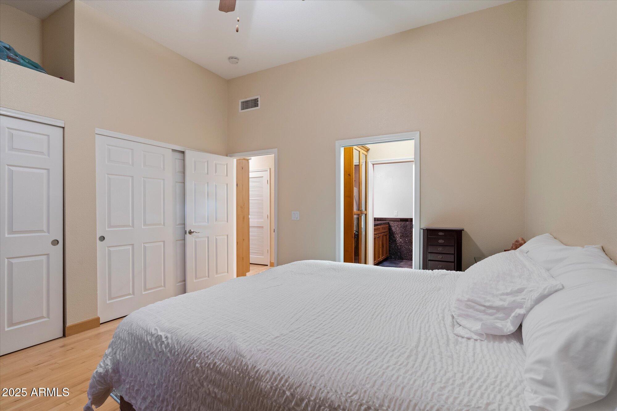 7272 East Gainey Ranch Road, Unit 104 Scottsdale, AZ 85258 - Photo 22 of 45 a bedroom with a bed and a mirror