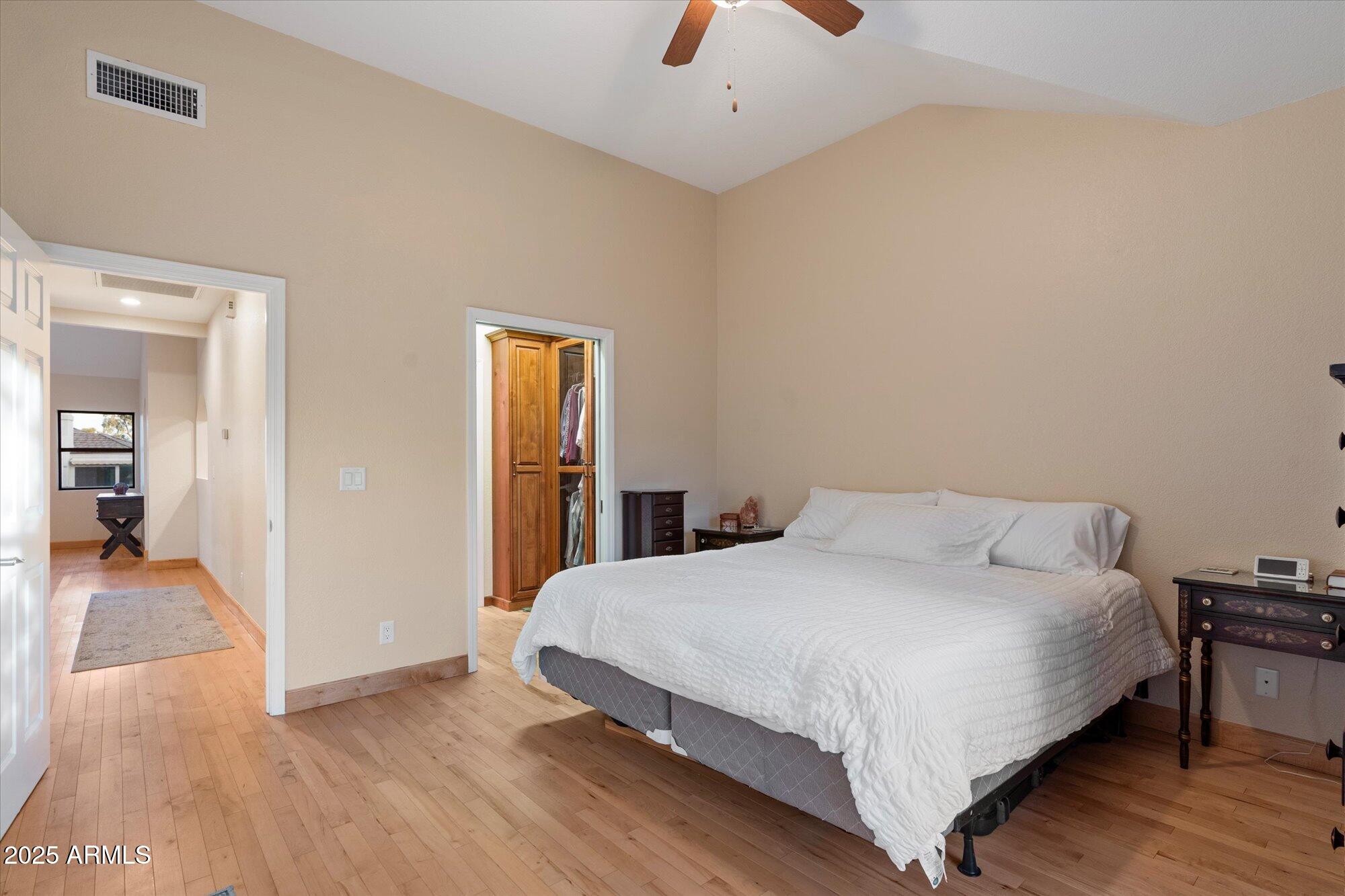 7272 East Gainey Ranch Road, Unit 104 Scottsdale, AZ 85258 - Photo 23 of 45 a bedroom with a bed and wooden floor