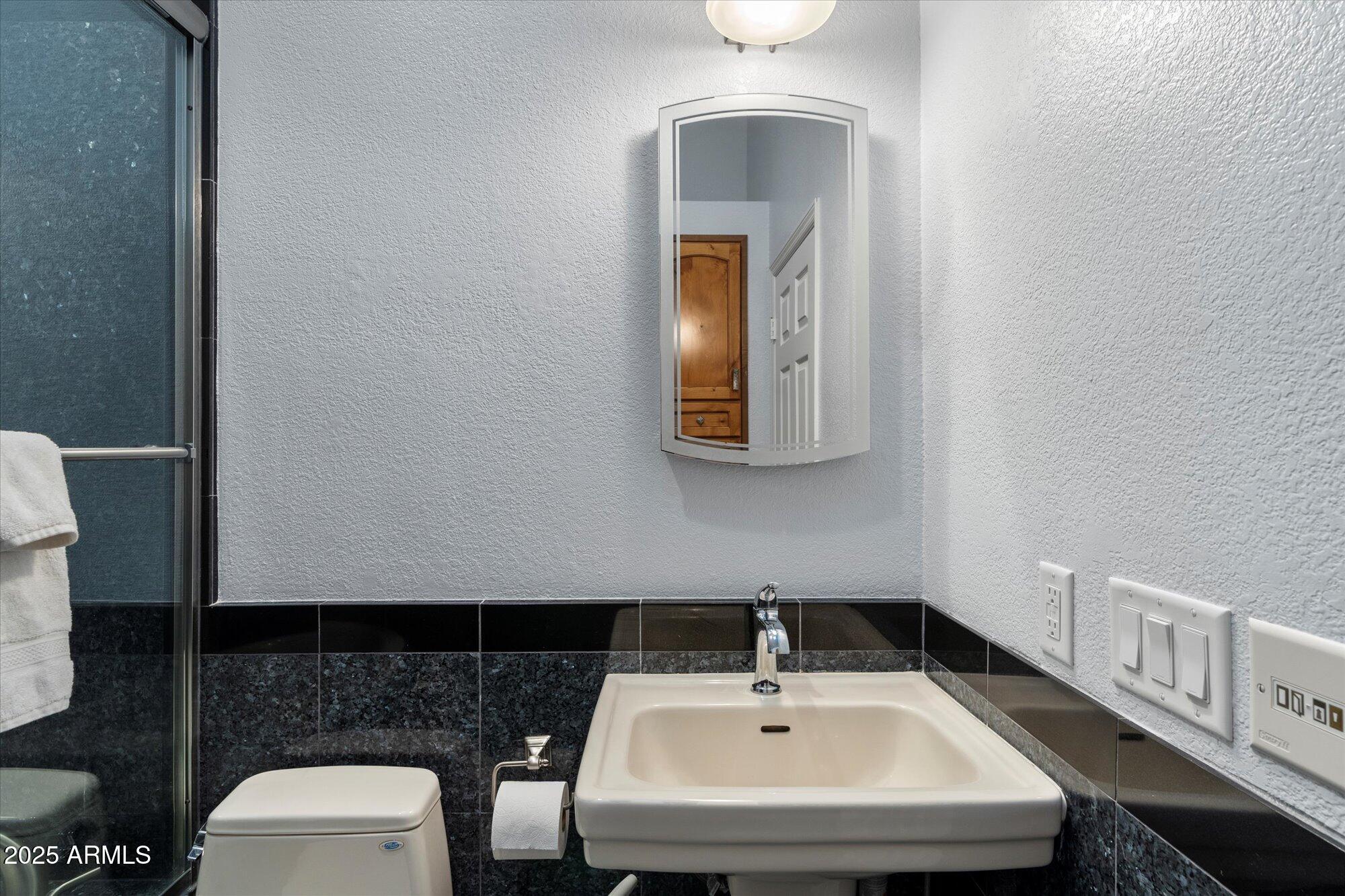 7272 East Gainey Ranch Road, Unit 104 Scottsdale, AZ 85258 - Photo 30 of 45 a bathroom with a sink and a mirror