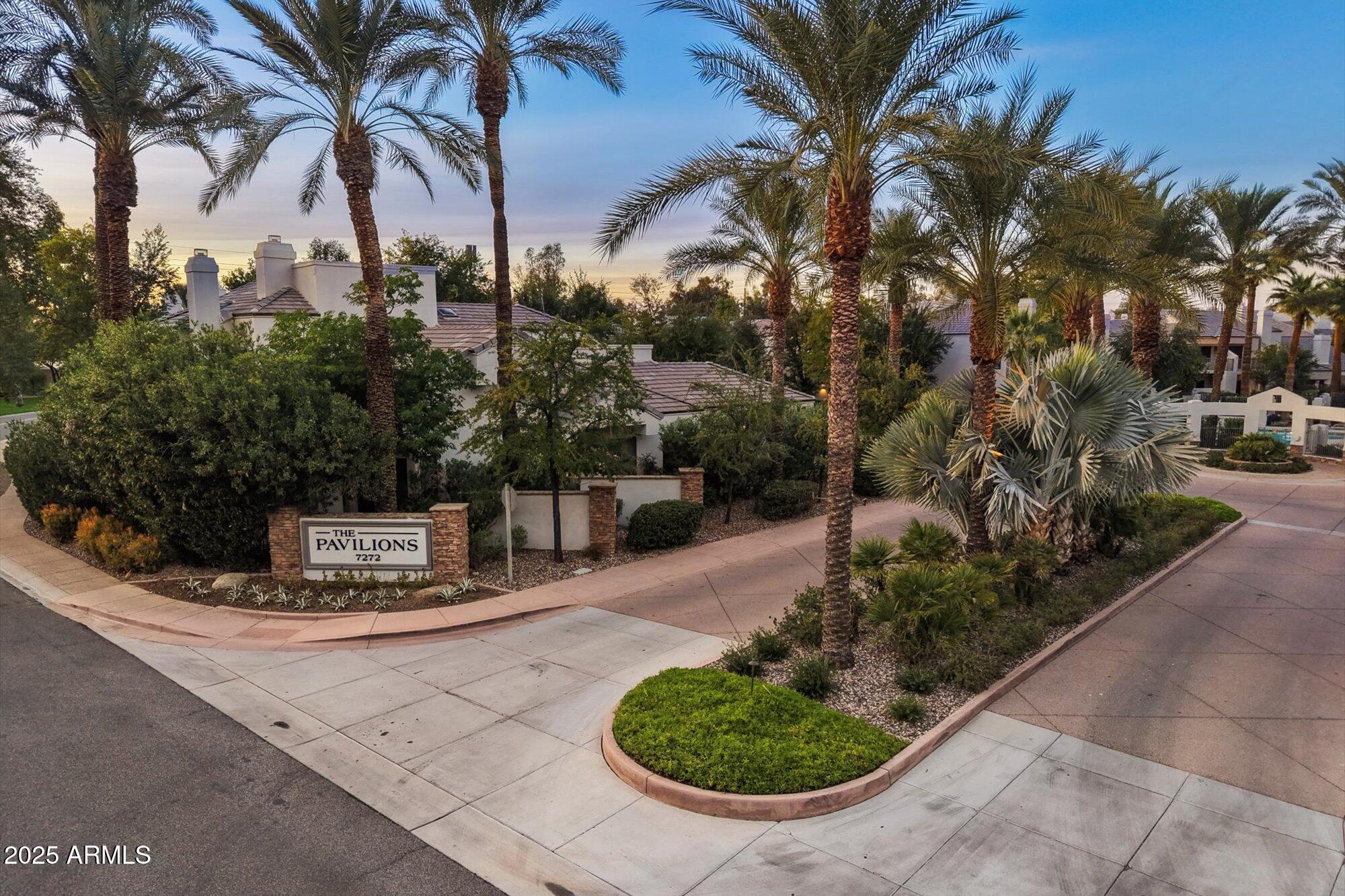 7272 East Gainey Ranch Road, Unit 104 Scottsdale, AZ 85258 - Photo 40 of 45 a view of a house with a yard potted plants and large trees