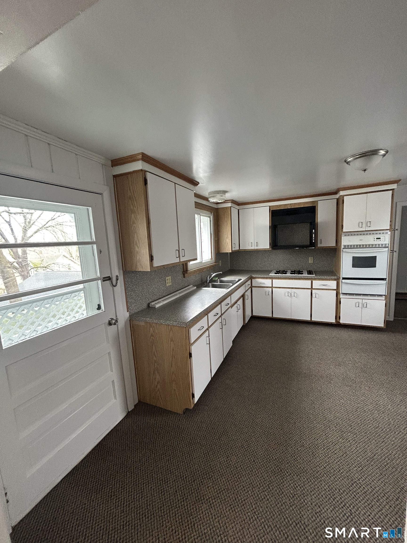 73 Peck Street, Unit 2 Norwich, CT 06360 - Photo 5 of 21 a kitchen with stainless steel appliances a refrigerator a stove a microwave and a window