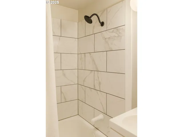 a view of a room that has a bed and a table in it