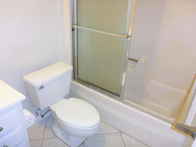a white toilet sitting next to a bath tub and shower