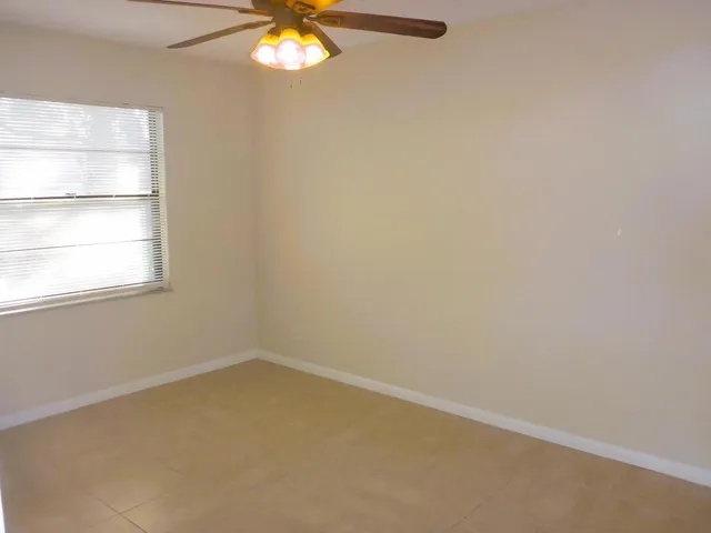 a view of a room with window and ceiling fan