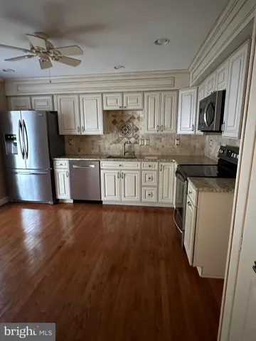 a kitchen with stainless steel appliances granite countertop a sink a stove a refrigerator and cabinets