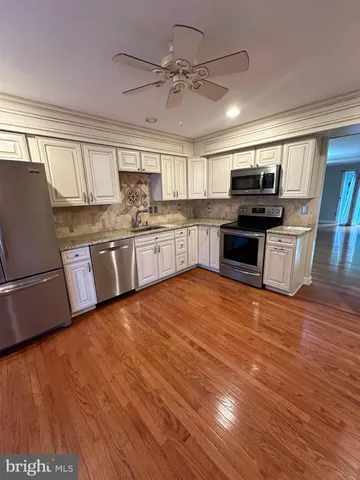 a kitchen with stainless steel appliances granite countertop a sink dishwasher stove and refrigerator