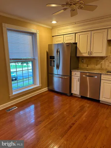a kitchen with granite countertop wooden floors and stainless steel appliances