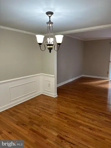 a view of a room with wooden floor and chandelier