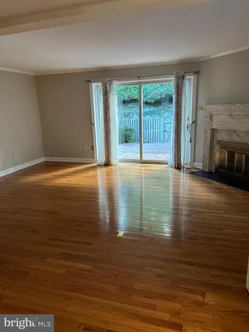 a view of an empty room with glass door and a window