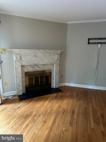a view of empty room with wooden floor and fireplace
