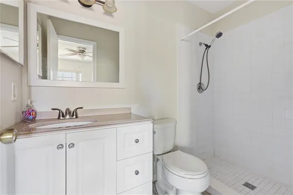 a bathroom with a granite countertop sink toilet and a mirror