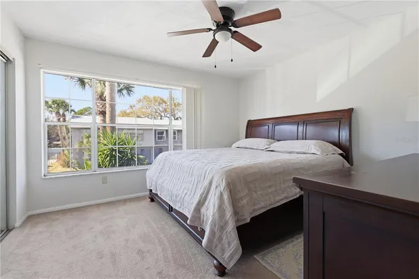 a bed sitting in a bedroom next to a window