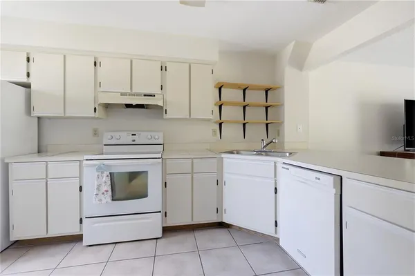 a kitchen with white cabinets and white appliances