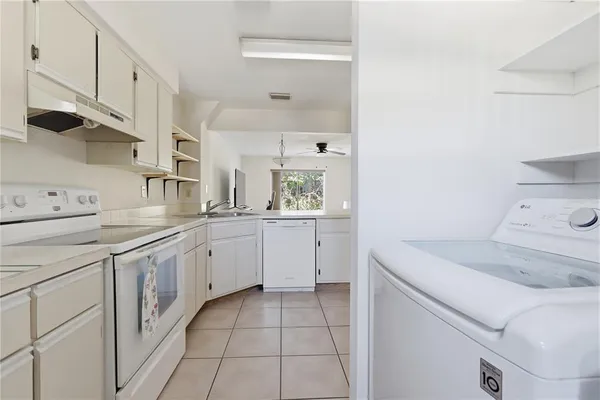 a utility room with cabinets washer and dryer