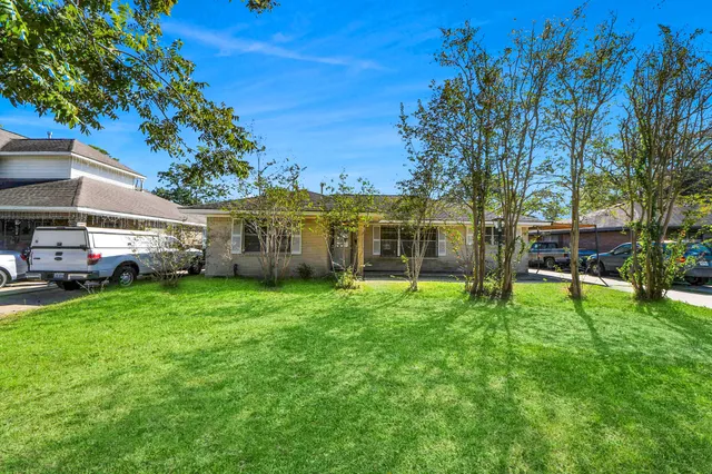a view of a yard with a house and a large tree