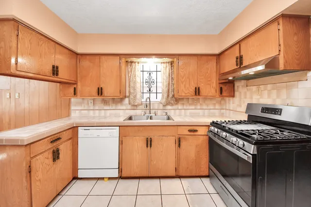 a kitchen with a stove sink and cabinets