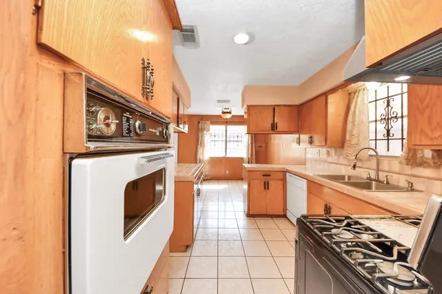 a kitchen with stainless steel appliances a stove a sink and a refrigerator
