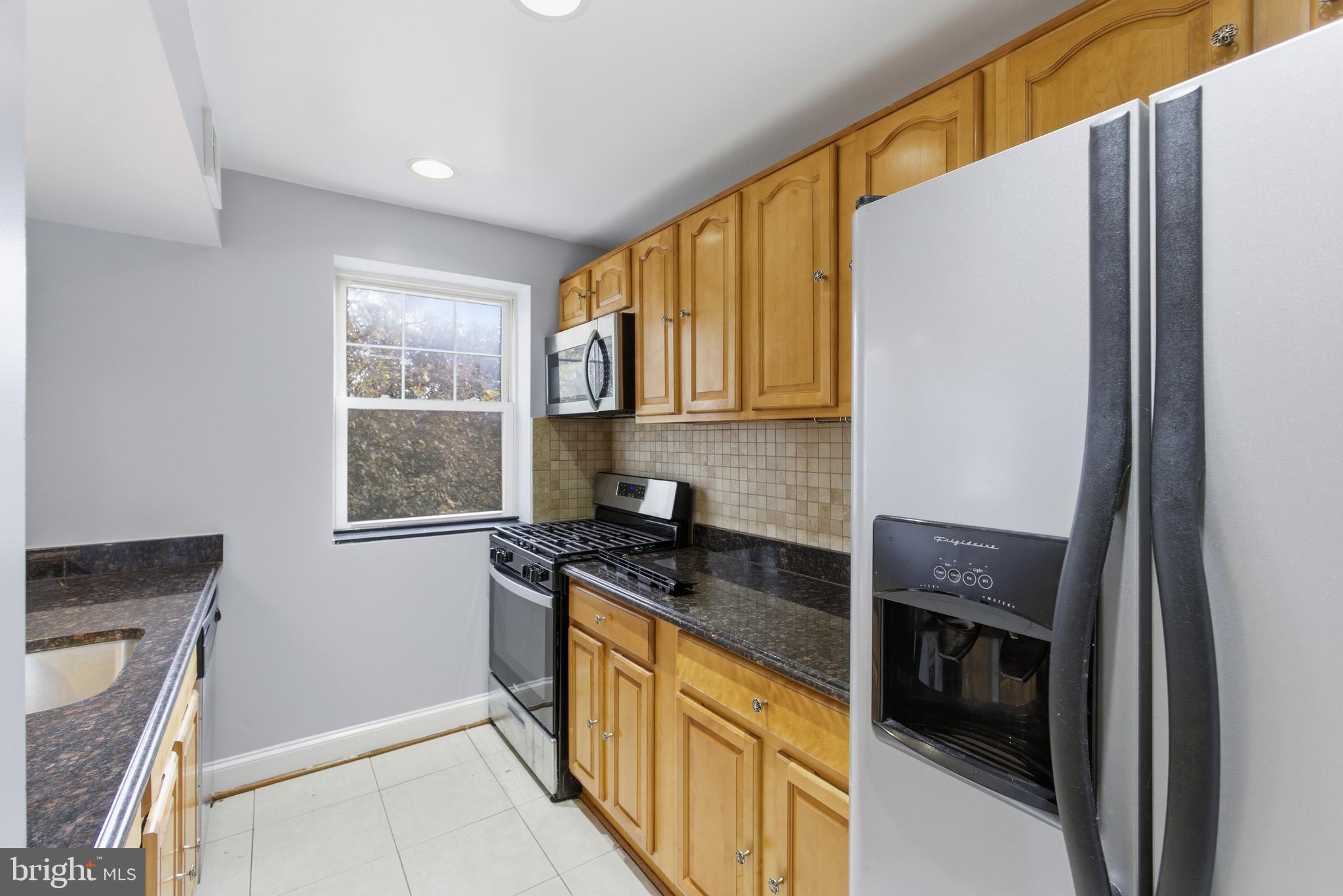 3872 9th Street Southeast, Unit 201 Washington, DC 20032 - Photo 11 of 17 a kitchen with granite countertop cabinets and window