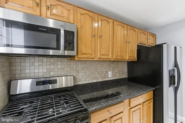 a kitchen with stainless steel appliances granite countertop a stove a microwave and a sink