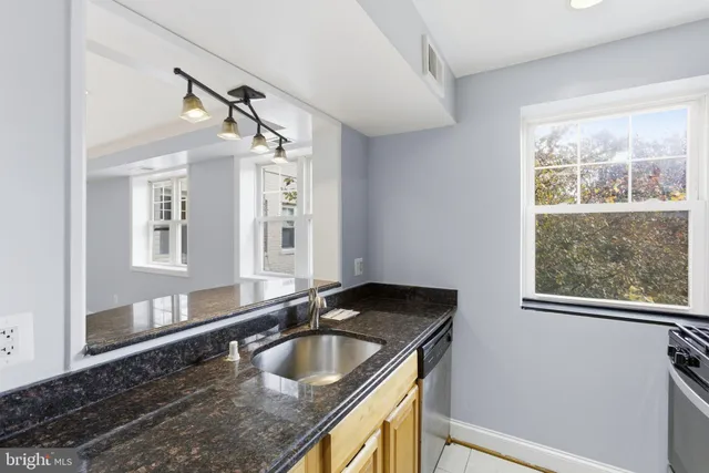 a bathroom with a granite countertop sink and a large mirror