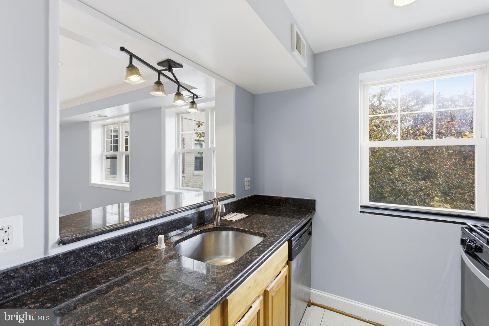 3872 9th Street Southeast, Unit 201 Washington, DC 20032 - Photo 16 of 17 a bathroom with a granite countertop sink and a large mirror