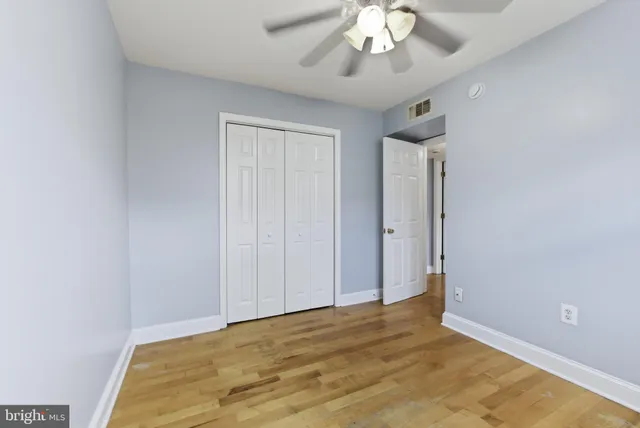 a view of an empty room with a chandelier fan