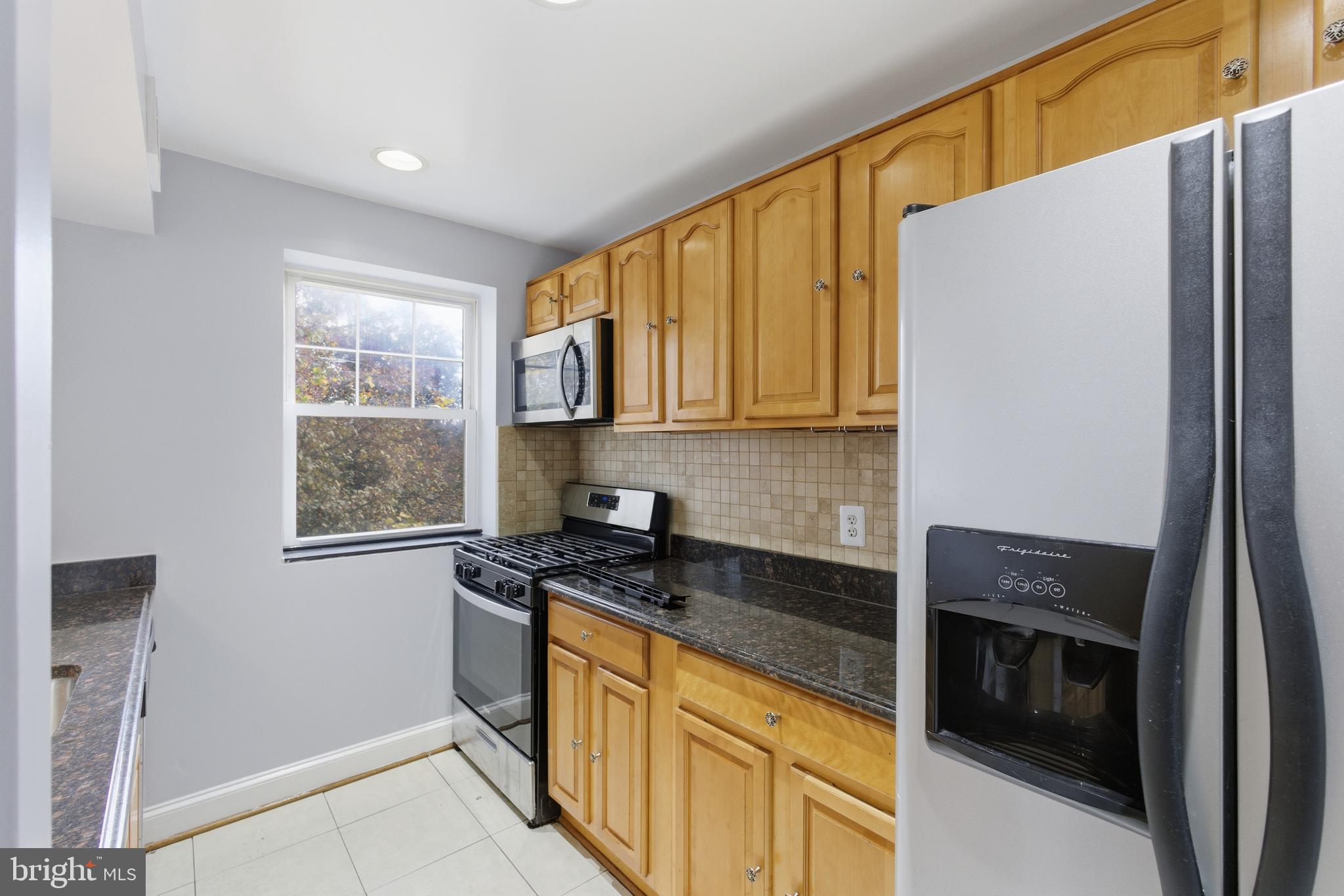 3872 9th Street Southeast, Unit 201 Washington, DC 20032 - Photo 10 of 17 a kitchen with granite countertop cabinets stainless steel appliances and a window