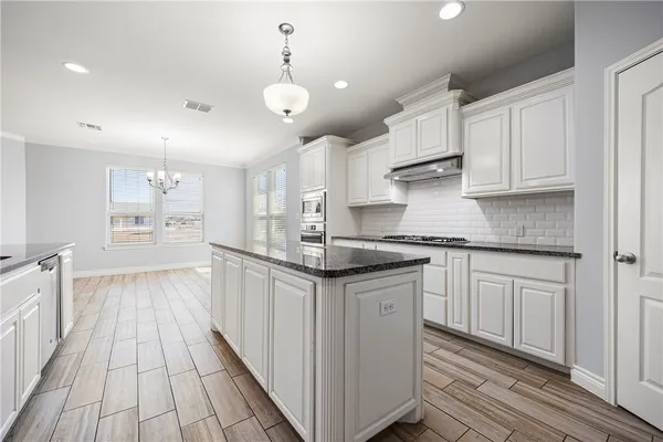 a kitchen with granite countertop a sink and cabinets