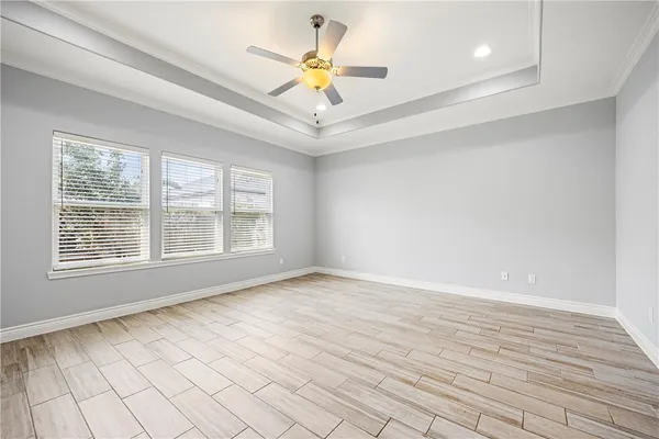 a view of an empty room with a window and a ceiling fan