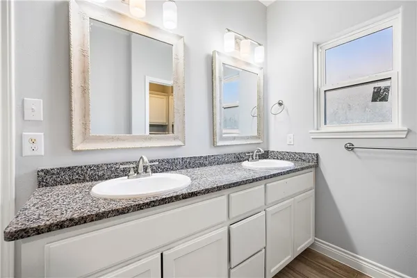 a bathroom with a granite countertop sink and a mirror
