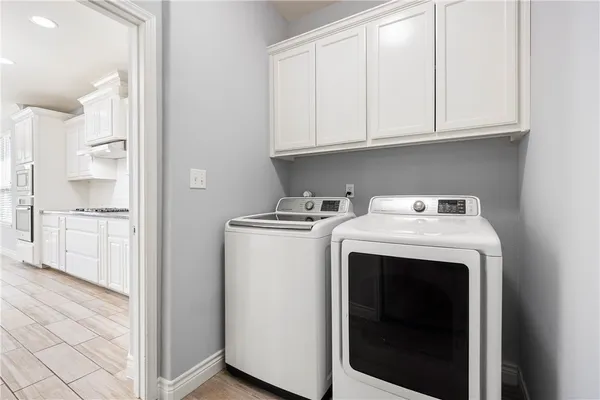 a view of washer and dryer with kitchen in the background