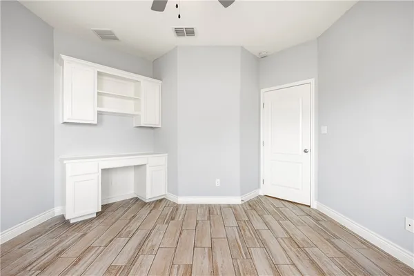 a view of empty room with wooden floor and fireplace