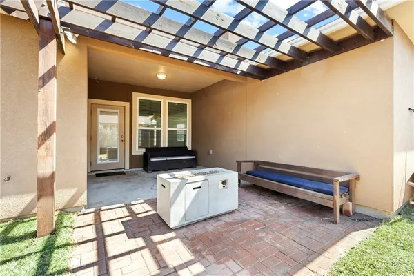 a backyard of a house with sofas table and chairs