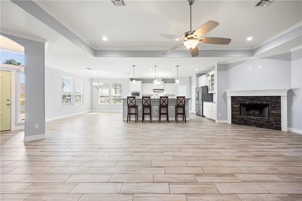 a view of a livingroom with furniture a fireplace wooden floor and chandelier