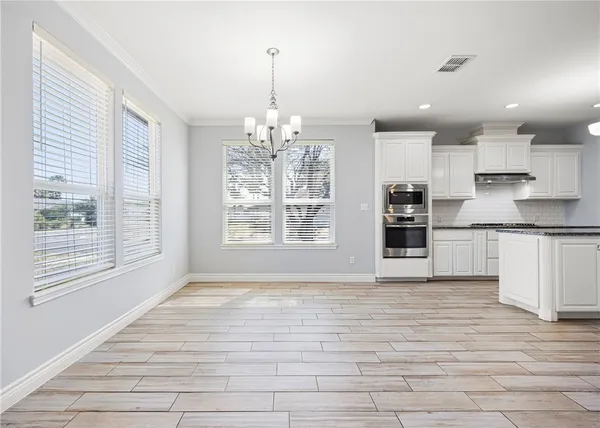 a view of kitchen with granite countertop cabinets and window