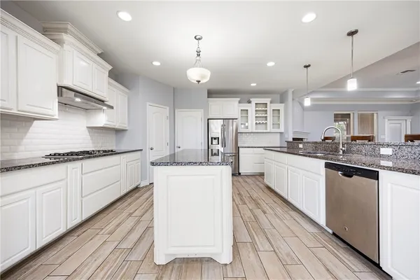 a large kitchen with kitchen island a sink stainless steel appliances and cabinets