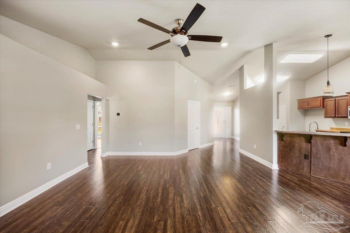 4015 Berry Circle Pace, FL 32571 - Photo 12 of 48 a view of an empty room and kitchen with wooden floor
