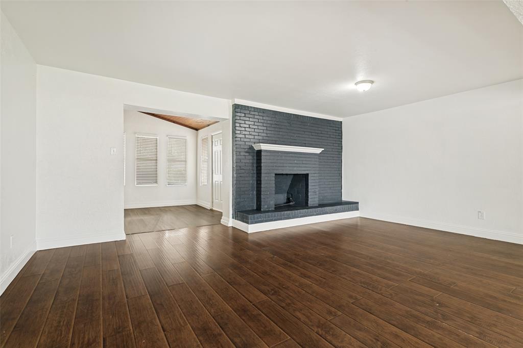 1904 Old Kirk Road Bedford, TX 76022 - Photo 7 of 25 a view of an empty room with wooden floor fireplace and a window
