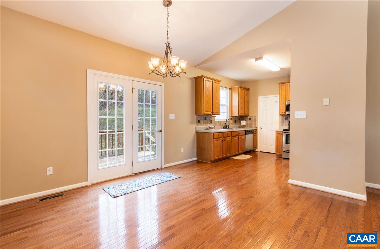 260 Geranium Road Ruckersville, VA 22968 - Photo 7 of 32 a view of an empty room with kitchen and wooden floor