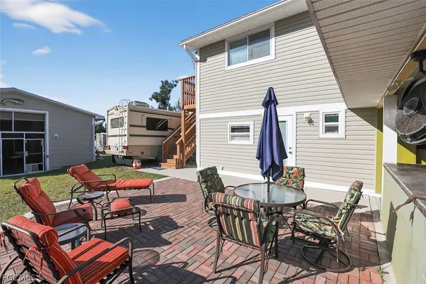 a patio with table and chairs and potted plants
