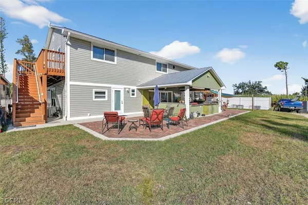 a view of a house with a patio and a yard