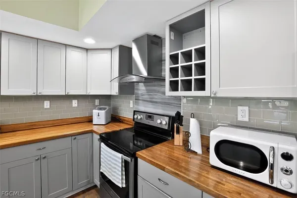 a kitchen with granite countertop a stove a sink and a microwave