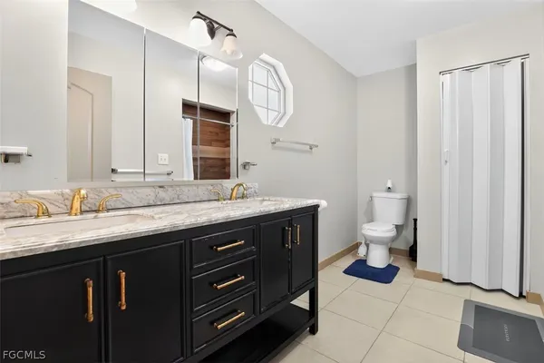 a spacious bathroom with a granite countertop sink a toilet and a mirror